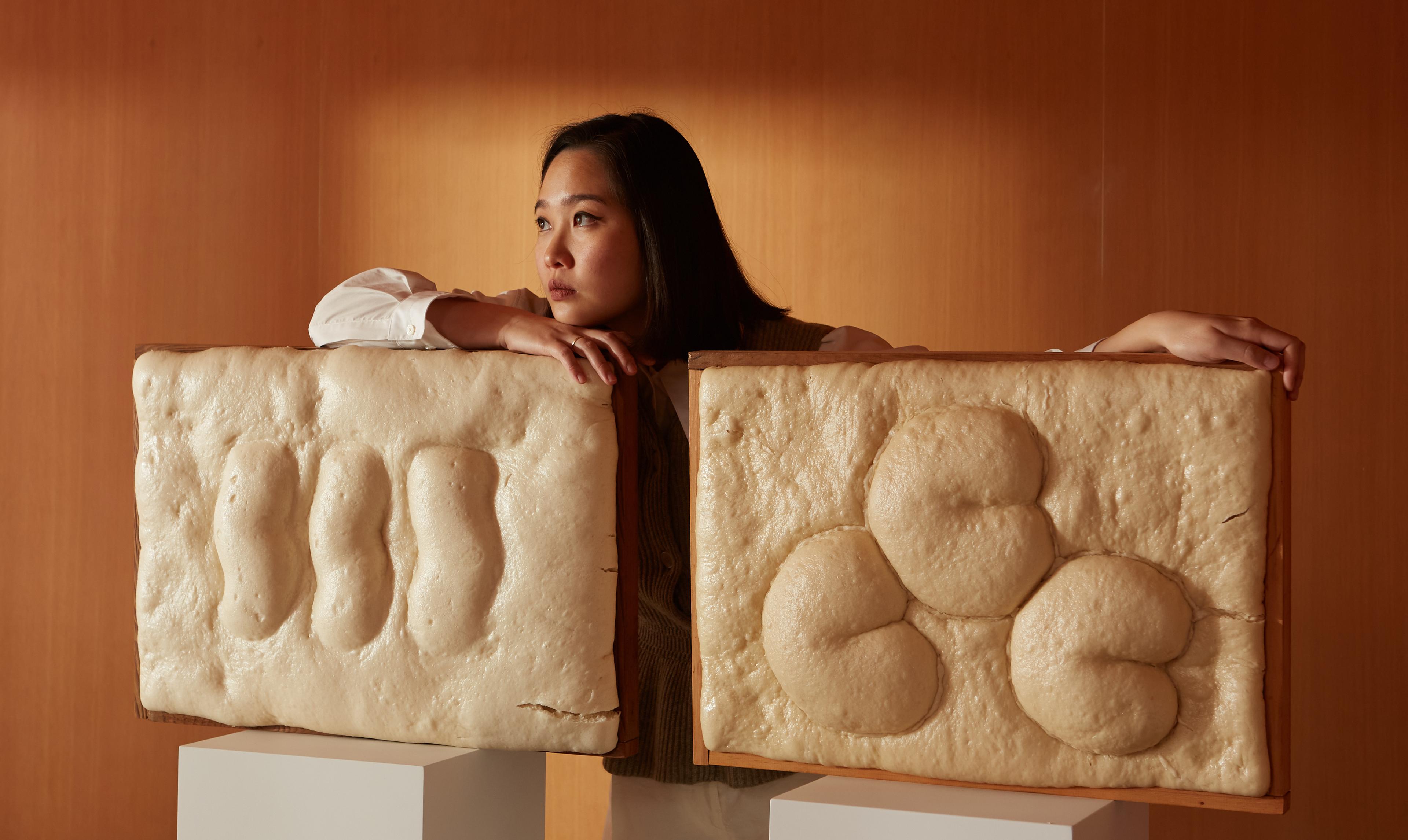 Erchen holds two art sculptures made of dough with fluffy BAO