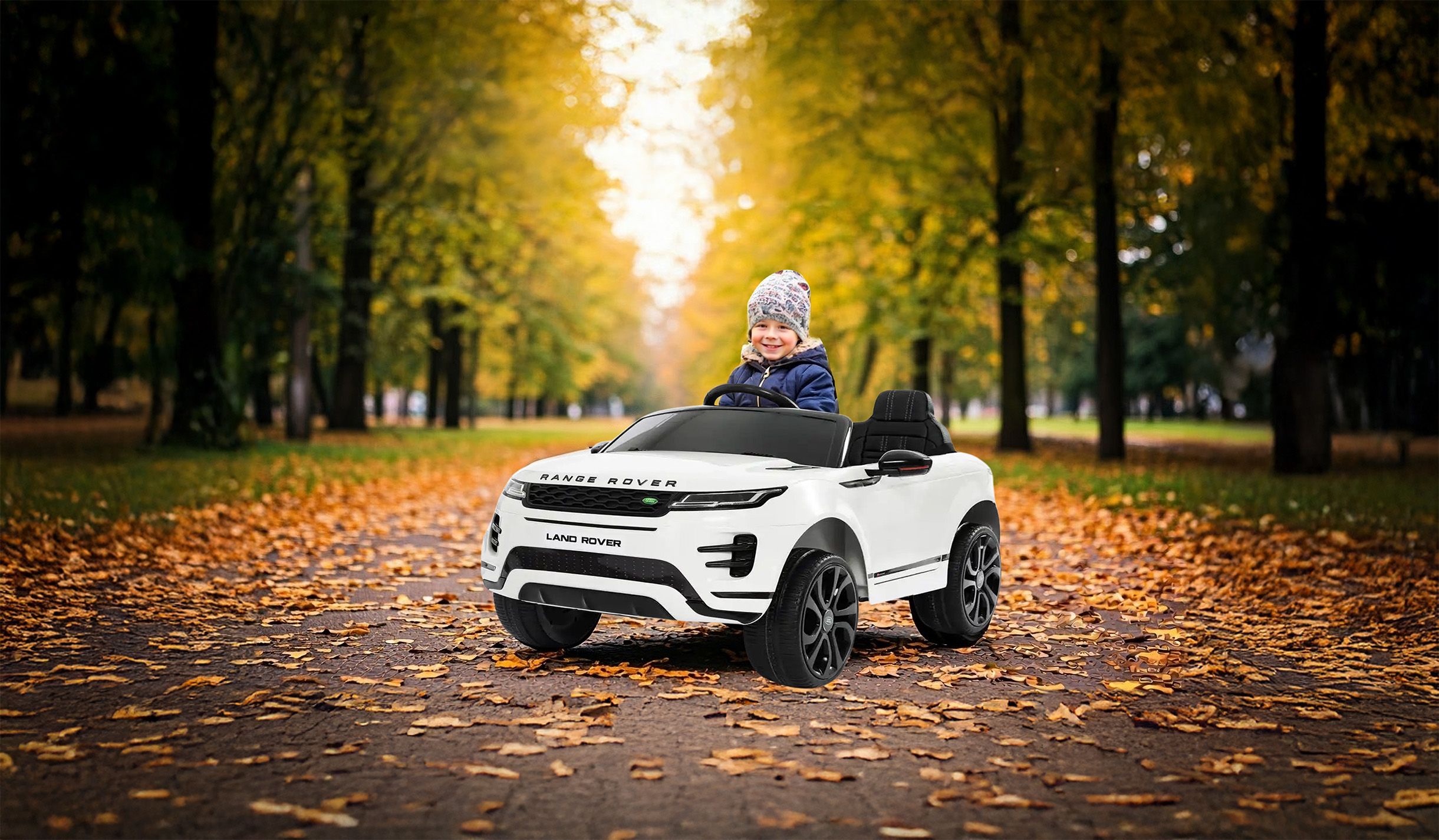 Bambino con macchina nel parco alberato