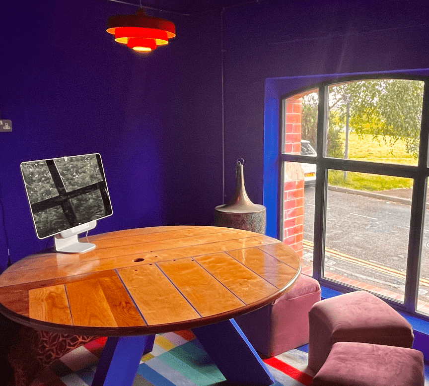 Blue room with round table and a monitor sat on top