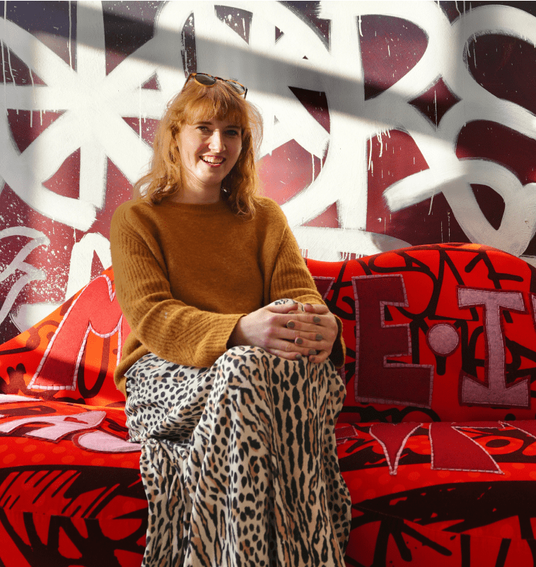 Women sitting on a sofa with graffiti in the background