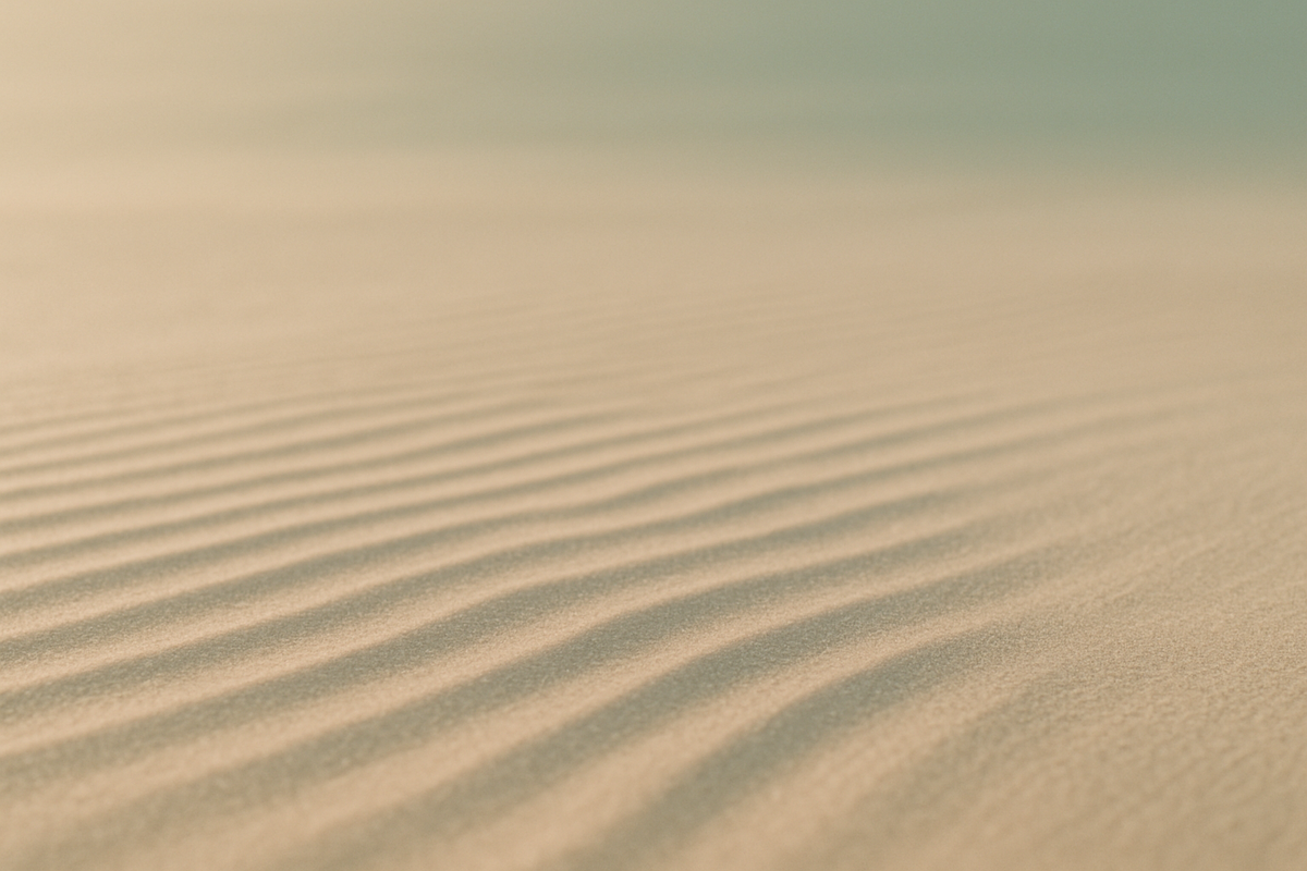 Even ripples in smooth sand fading into stillness