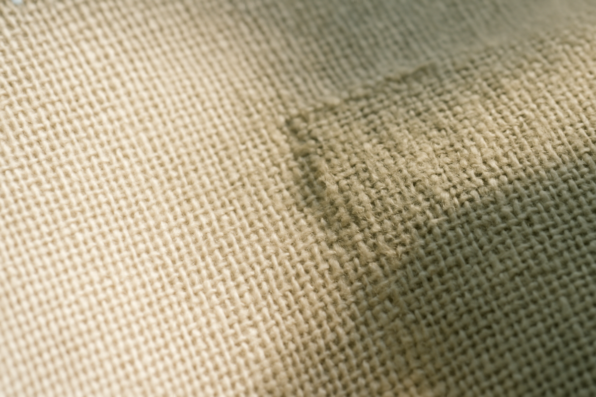 Close-up of woven linen in raking light showing even and irregular weave