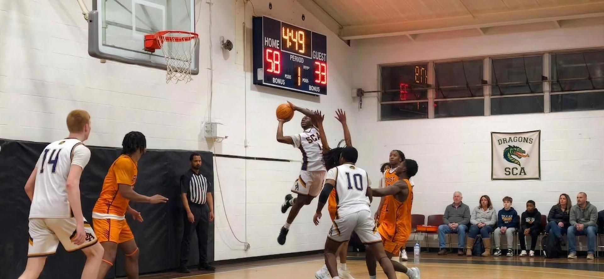 SCA Dragons basketball team in action — player going up for a layup during a home game