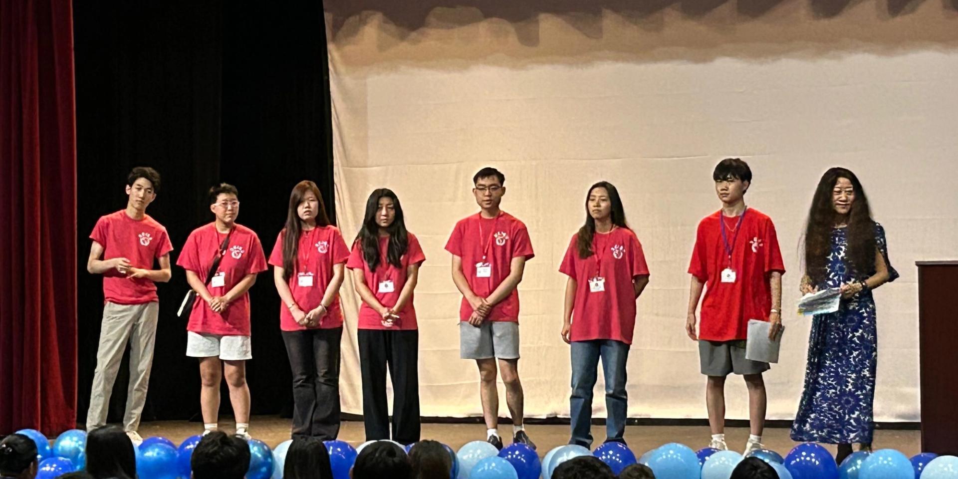 SCA students in red shirts presenting at the SCISS Opening Ceremony