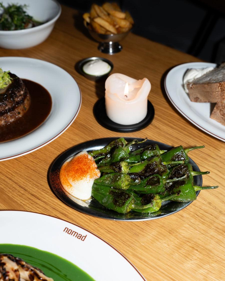 Pimientos de Padrón mit hausgemachter Aioli bei Kerzenlicht, dahinter Hacksteak, Pommes frites und Sauerteigbrot