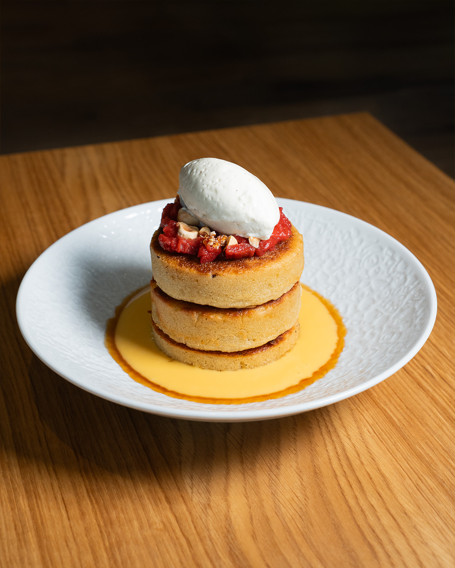 Bester dreistöckiger Pancake-Tower mit Beerenkompott, karamellisierten Nüssen und Mascarpone Nocke auf Maracujapüree im Restaurant Nomad