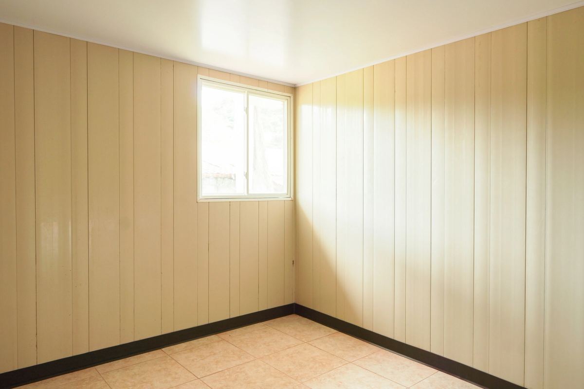 Un cuarto vacío de la casa modelo, con una ventana y piso de azulejo.