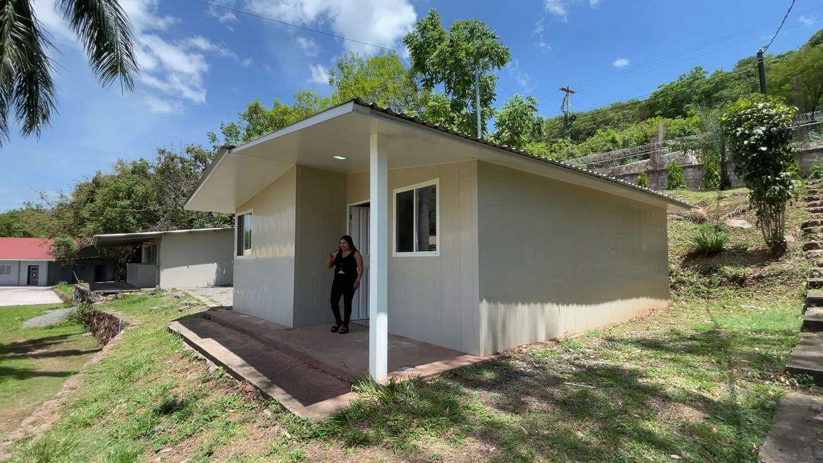 La casa modelo de frente, con una persona en el corredor.