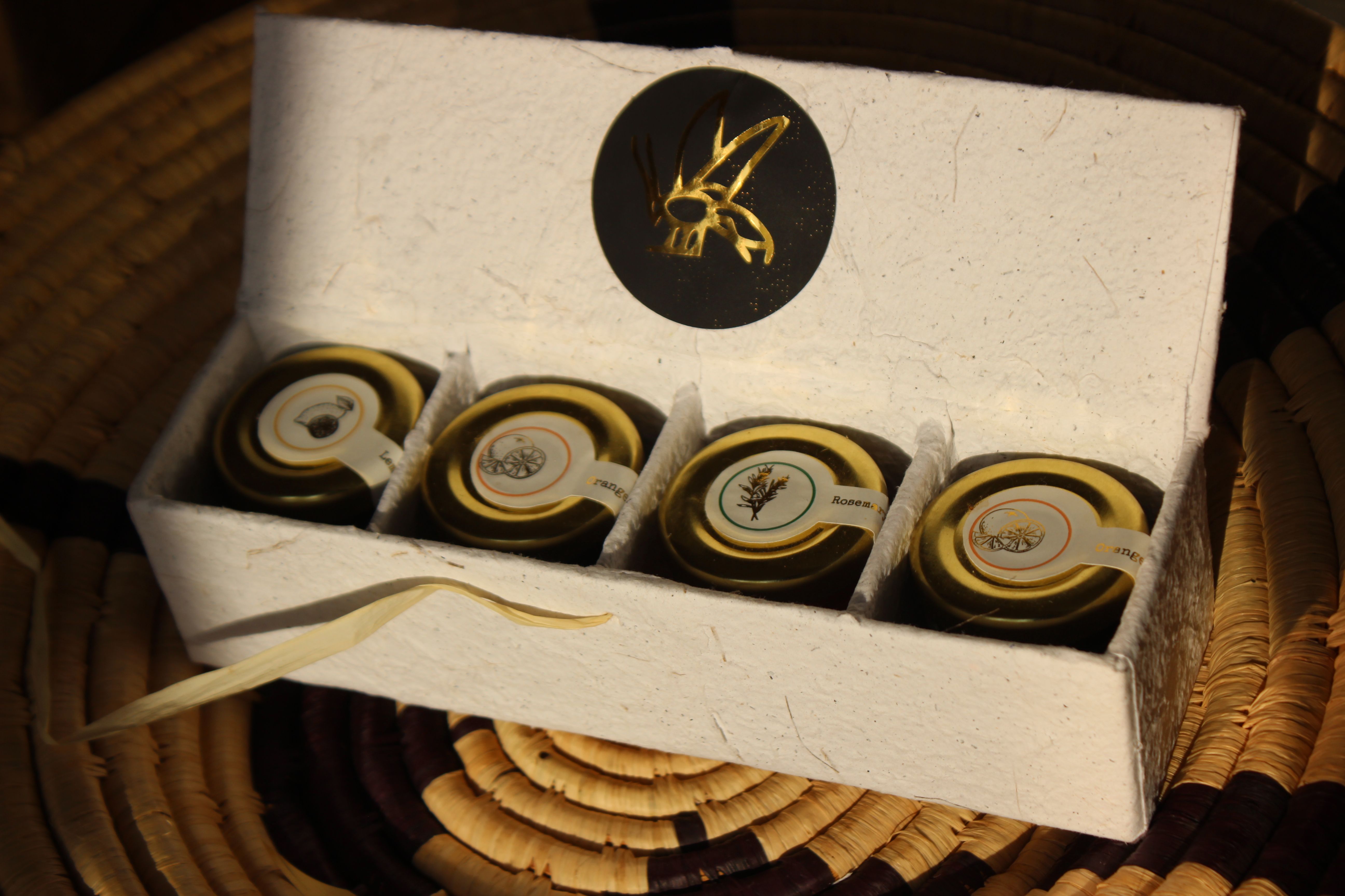 Luxury Ugandan gift set with honey jars and beeswax candles in recycled paper packaging