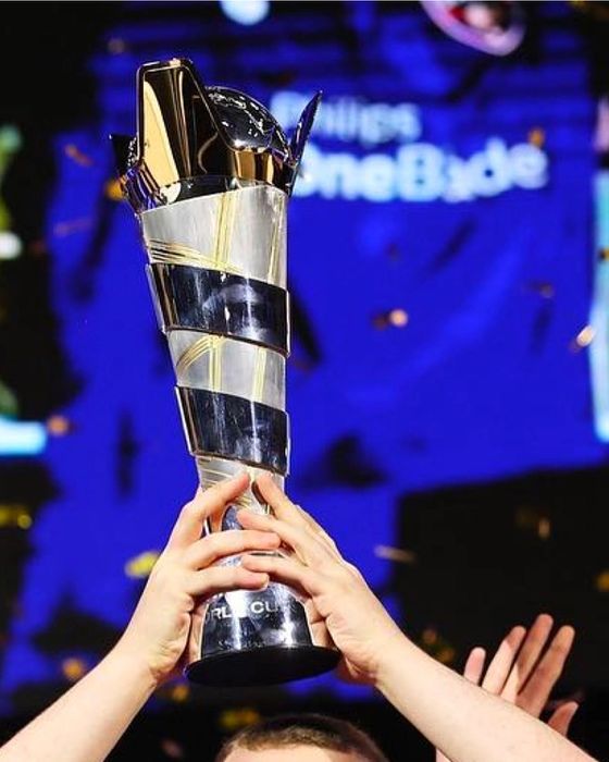 Two hands lifting up the FIFAe World Cup trophy.