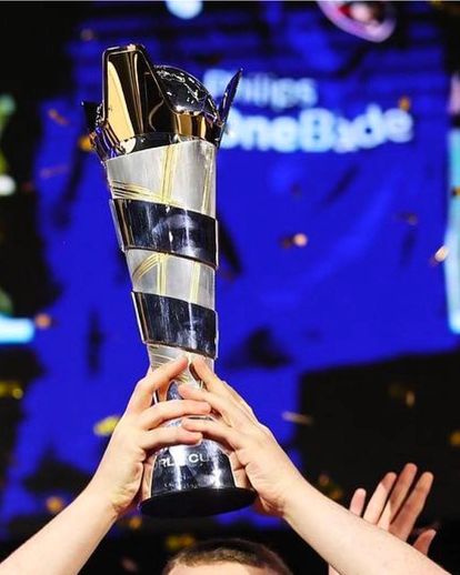 Two hands lifting up the FIFAe World Cup trophy.