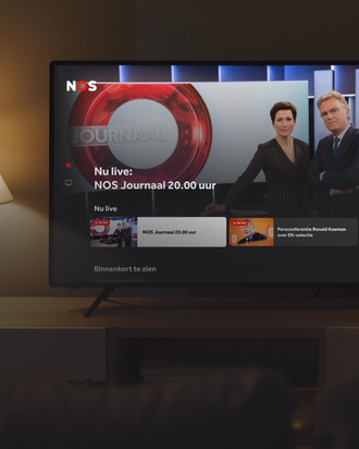 Living room setting with a smart TV displaying the NOS Live connected TV app.