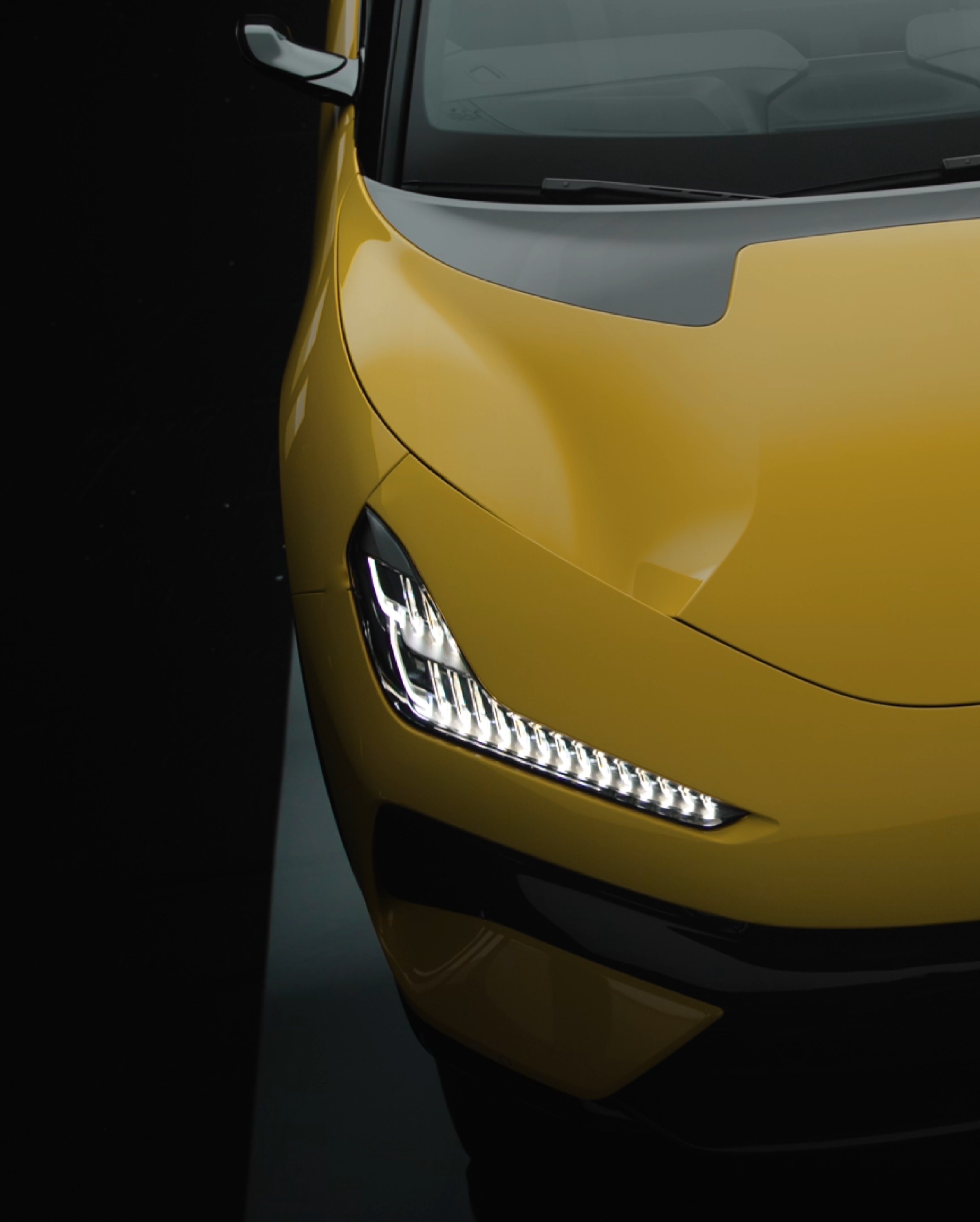 Front view of a yellow Lotus electrical vehicle.