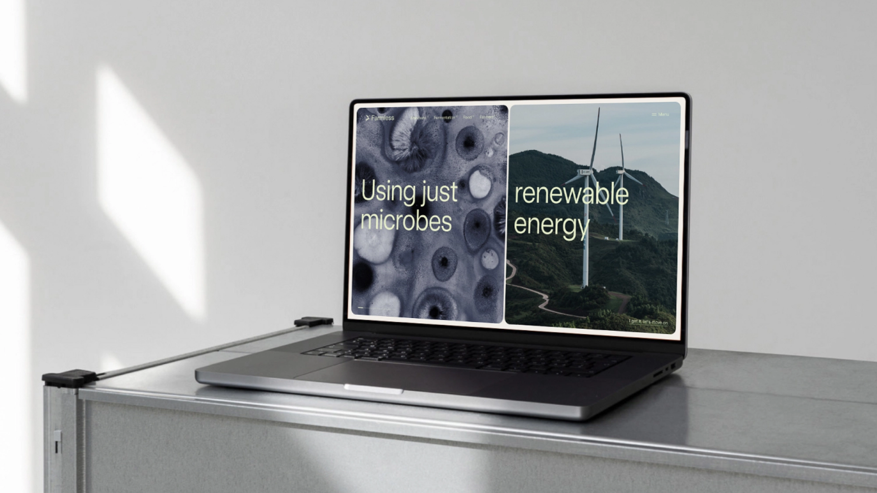 A laptop on a desk displaying two outings of Farmless. Being 'Using just microbes' and 'renewable energy'.