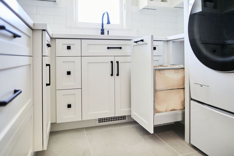 A perfect white shaker laundry room with pull-out hamper