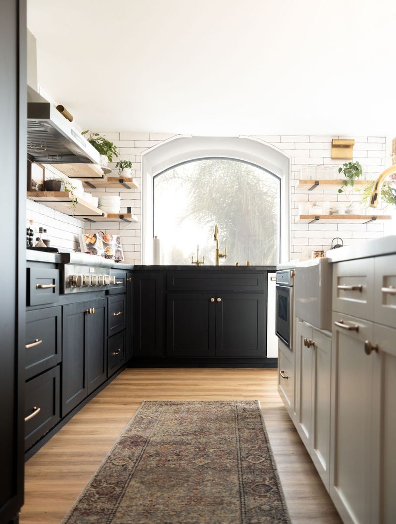 Black matte cabinets with gold handles and white farmhouse sink island