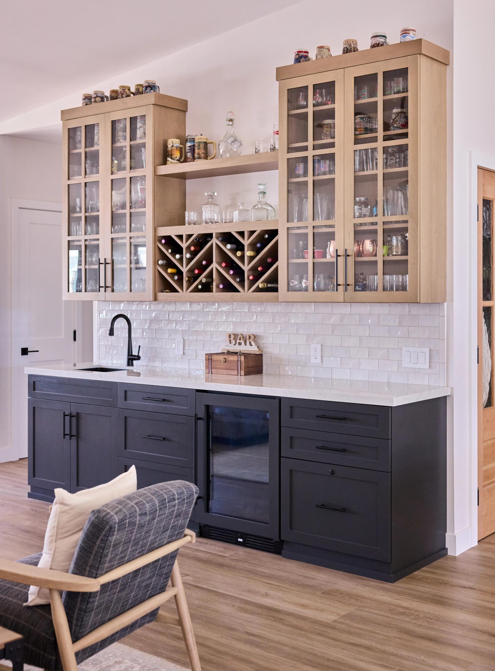 A custom wine bar with storage for bottles and glass front cabinetry