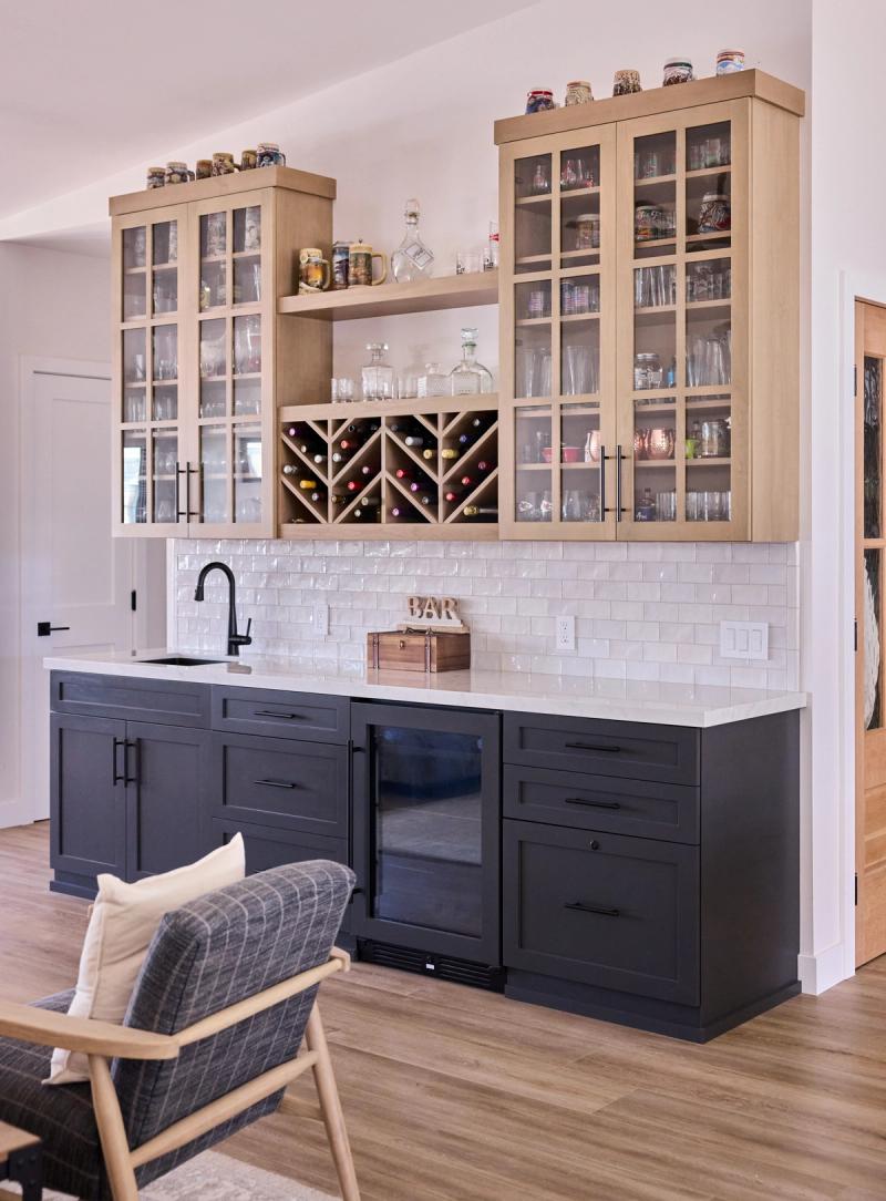 A custom wine bar with storage for bottles and glass front cabinetry