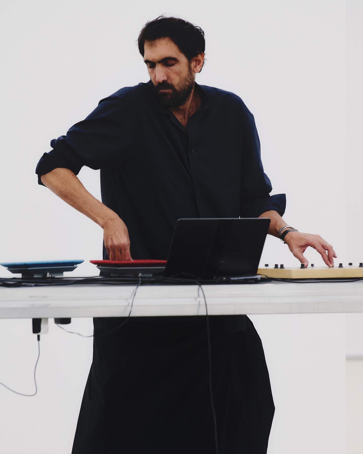 Tarek Atoui performing at a table of electronic and acoustic instruments.