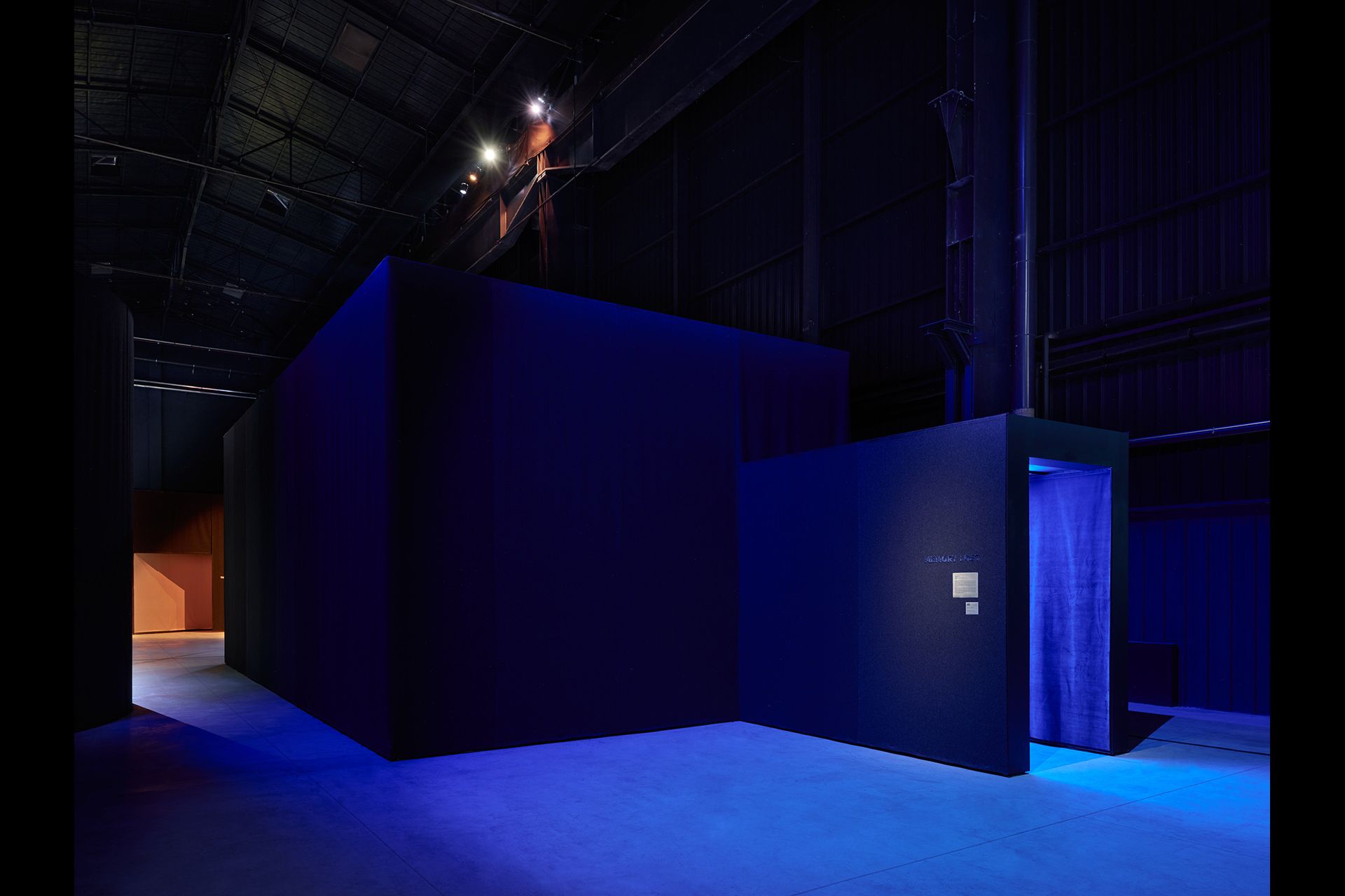 Pavilion interior with projected slideshow from Nan Goldin's retrospective at HangarBicocca.