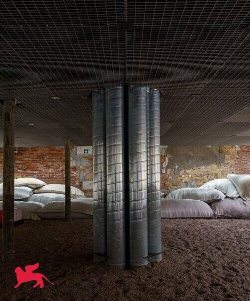 Visitors seated in the Bahrain pavilion under a square hovering ceiling supported by chains.