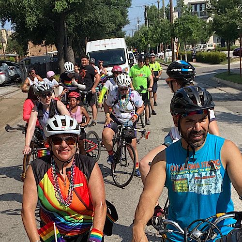 A group of cyclists rides through the streets of Dallas