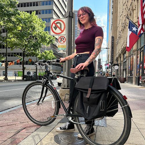 Cyclist stands with their bicycle in downtown Dallas
