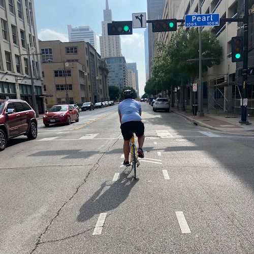 A man cycles in a shared bike path in downtown Dallas