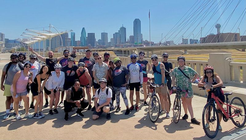 Cyclists pose in front of Dallas skyline after a group ride