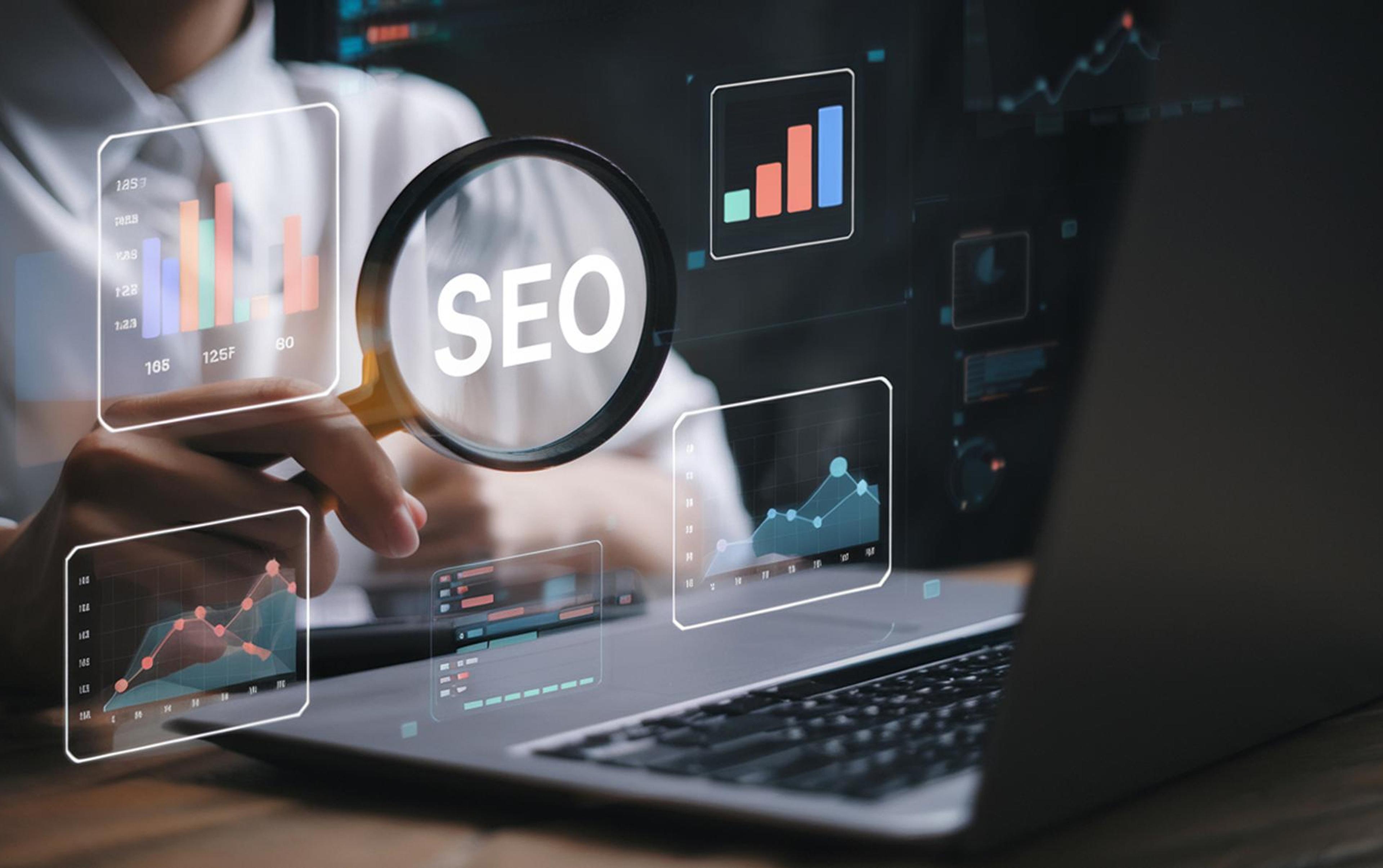 Lupe på en laptopskjerm over fargerike SEO-datadiagrammer symboliserer analyse av Google-rangeringer og søkemotoroptimalisering av en nettside.