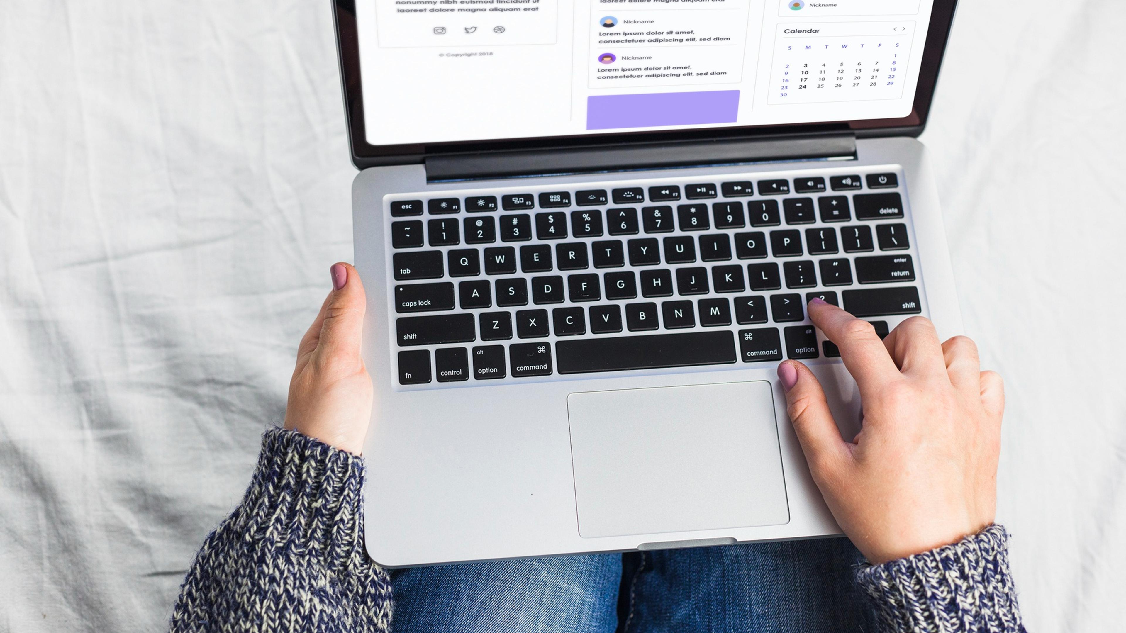 Nahaufnahme von Händen, die auf einer Laptop-Tastatur tippen