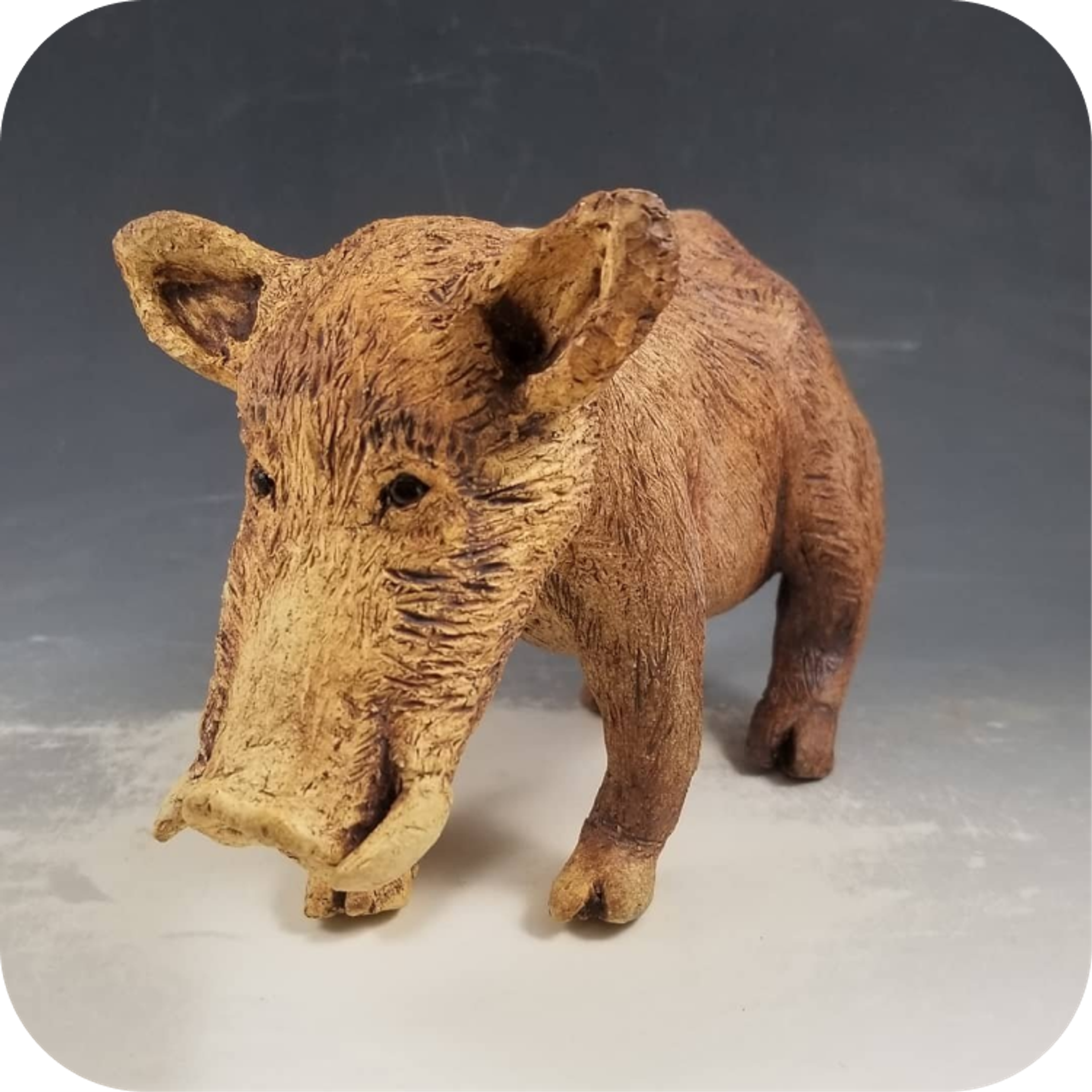 A detailed wooden sculpture of a wild boar on a neutral background