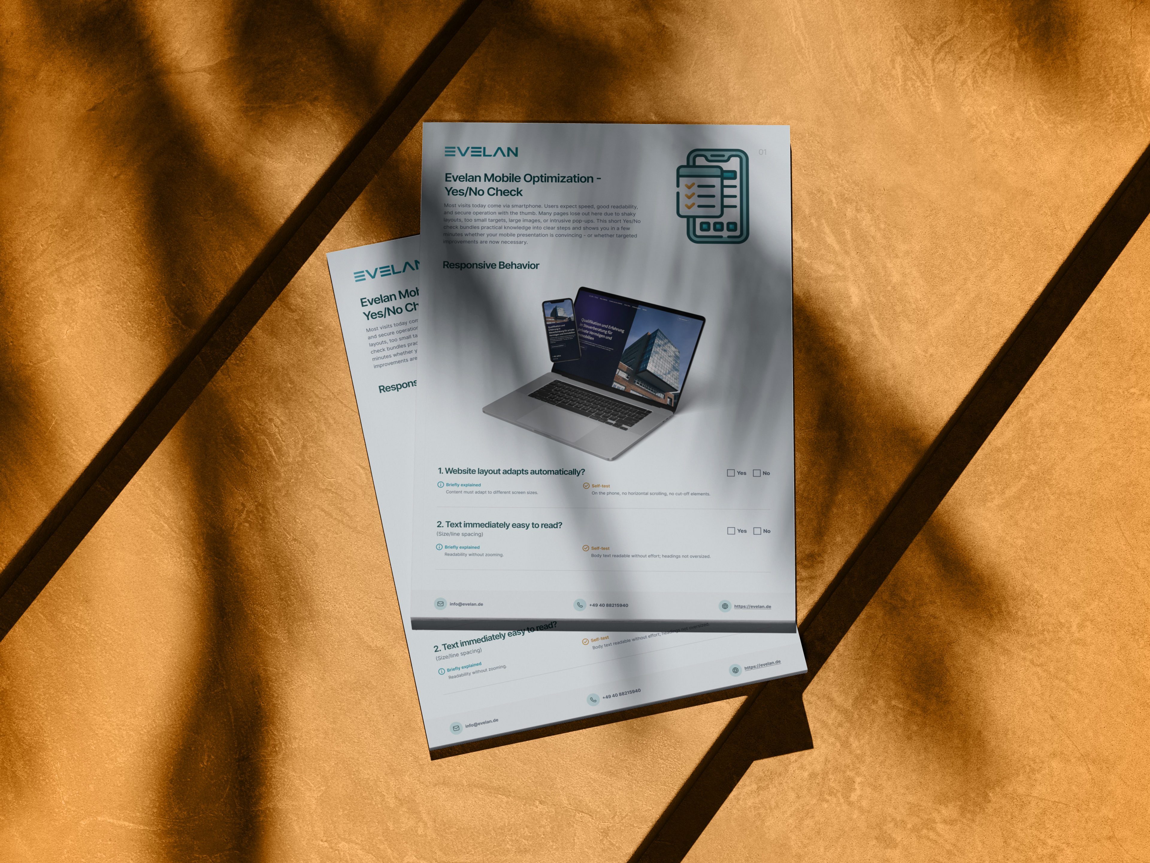 Two documents on mobile optimization on a brown desk; a laptop is pictured.