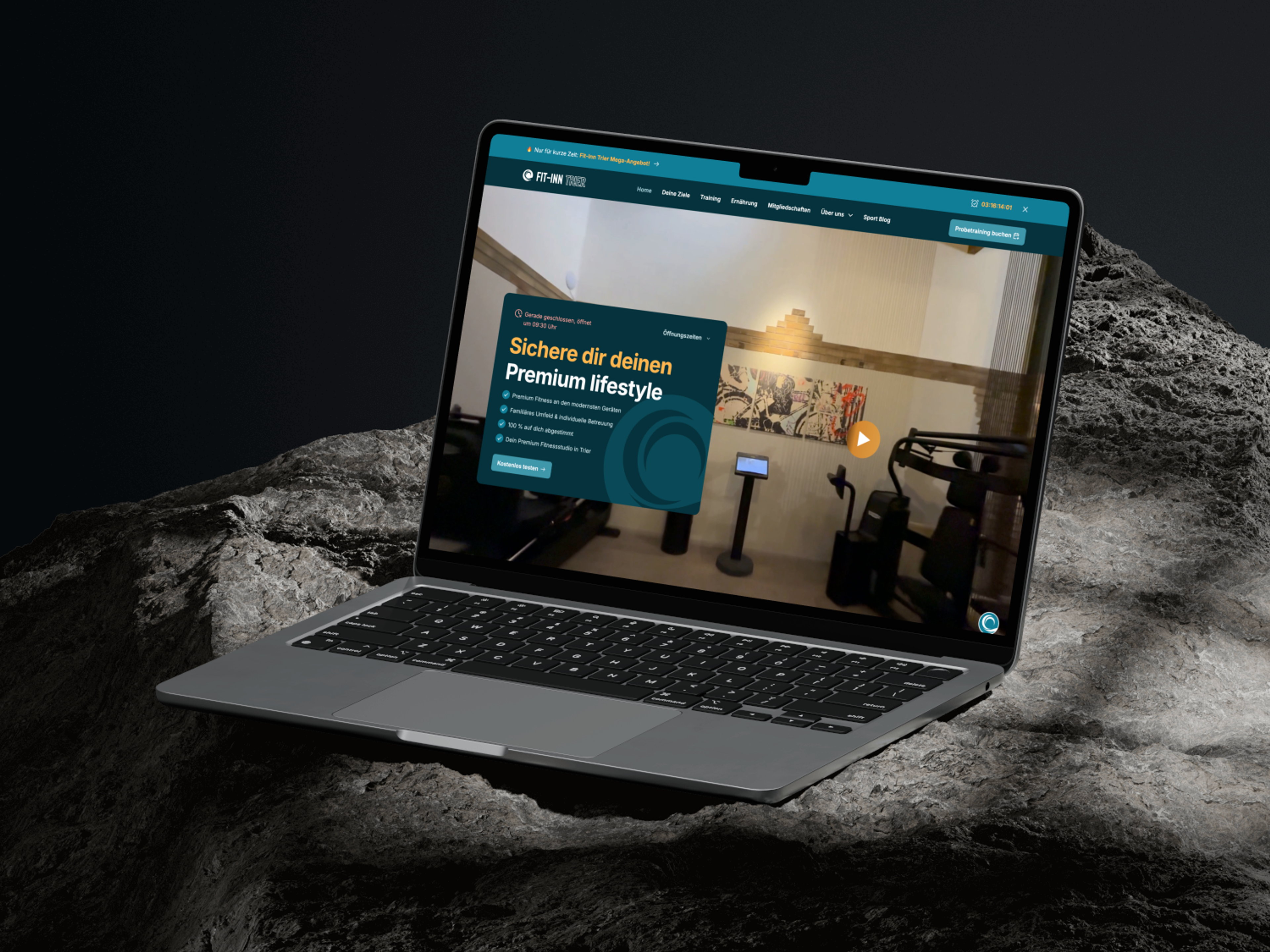 En bærbar datamaskin viser en treningsnettside med teksten "Secure your premium lifestyle", plassert på en stein.