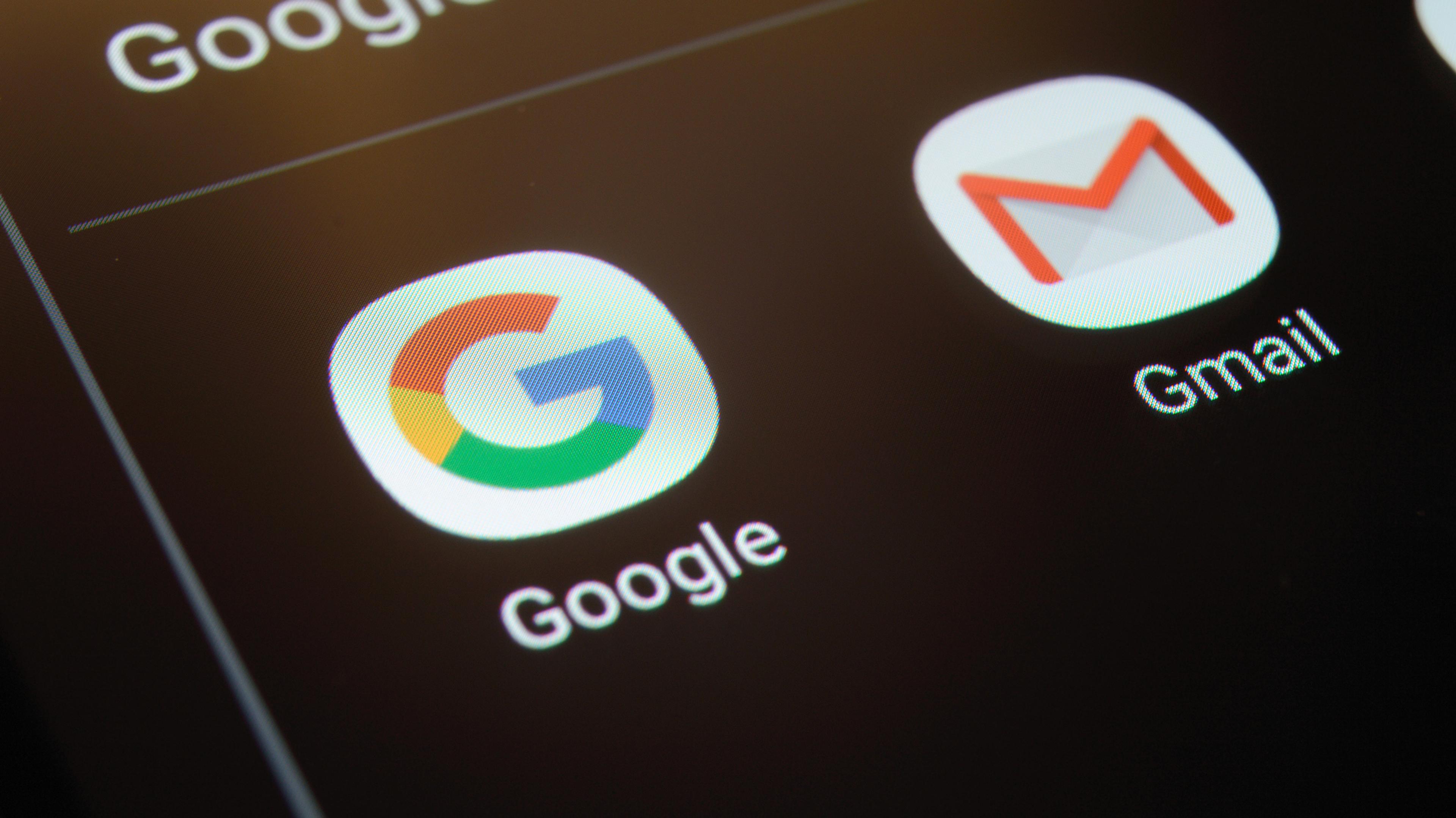 Логотип Google и значок Gmail на тёмном экране смартфона