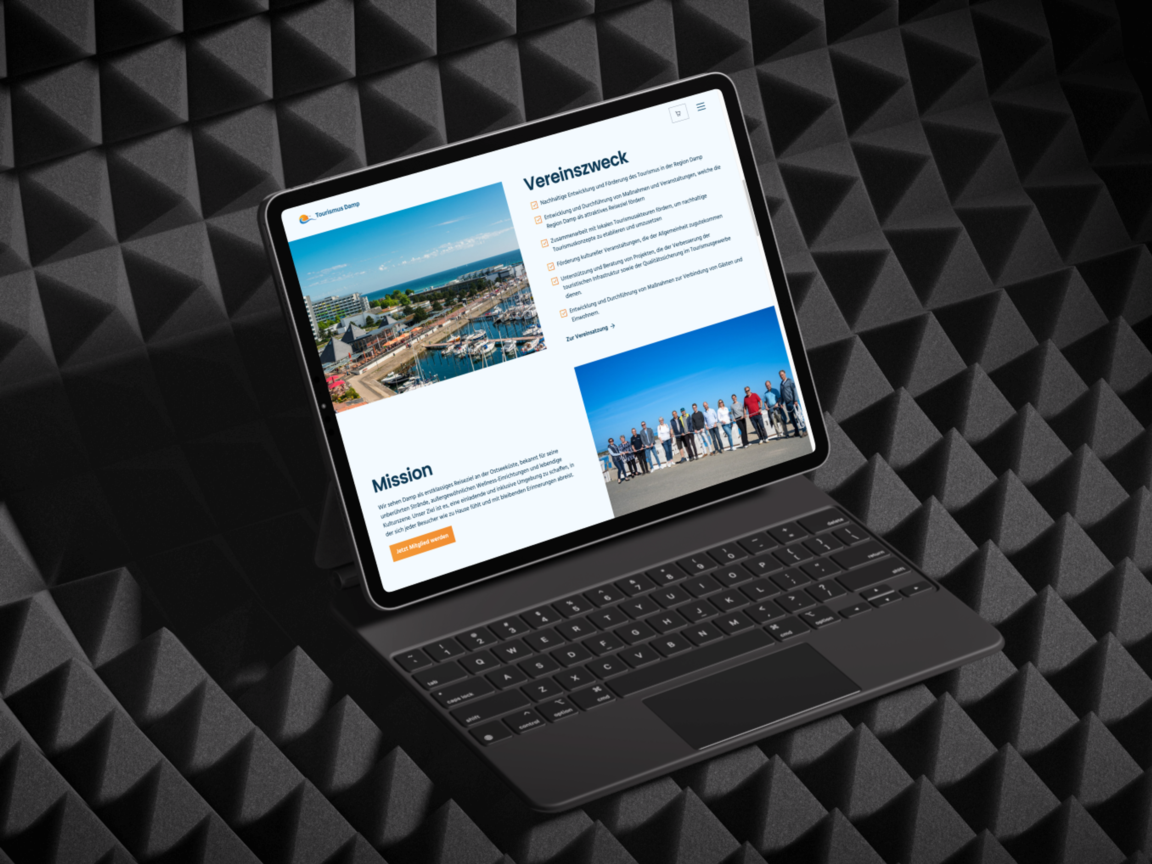 A tablet with an open website standing in front of a wall of acoustic foam.