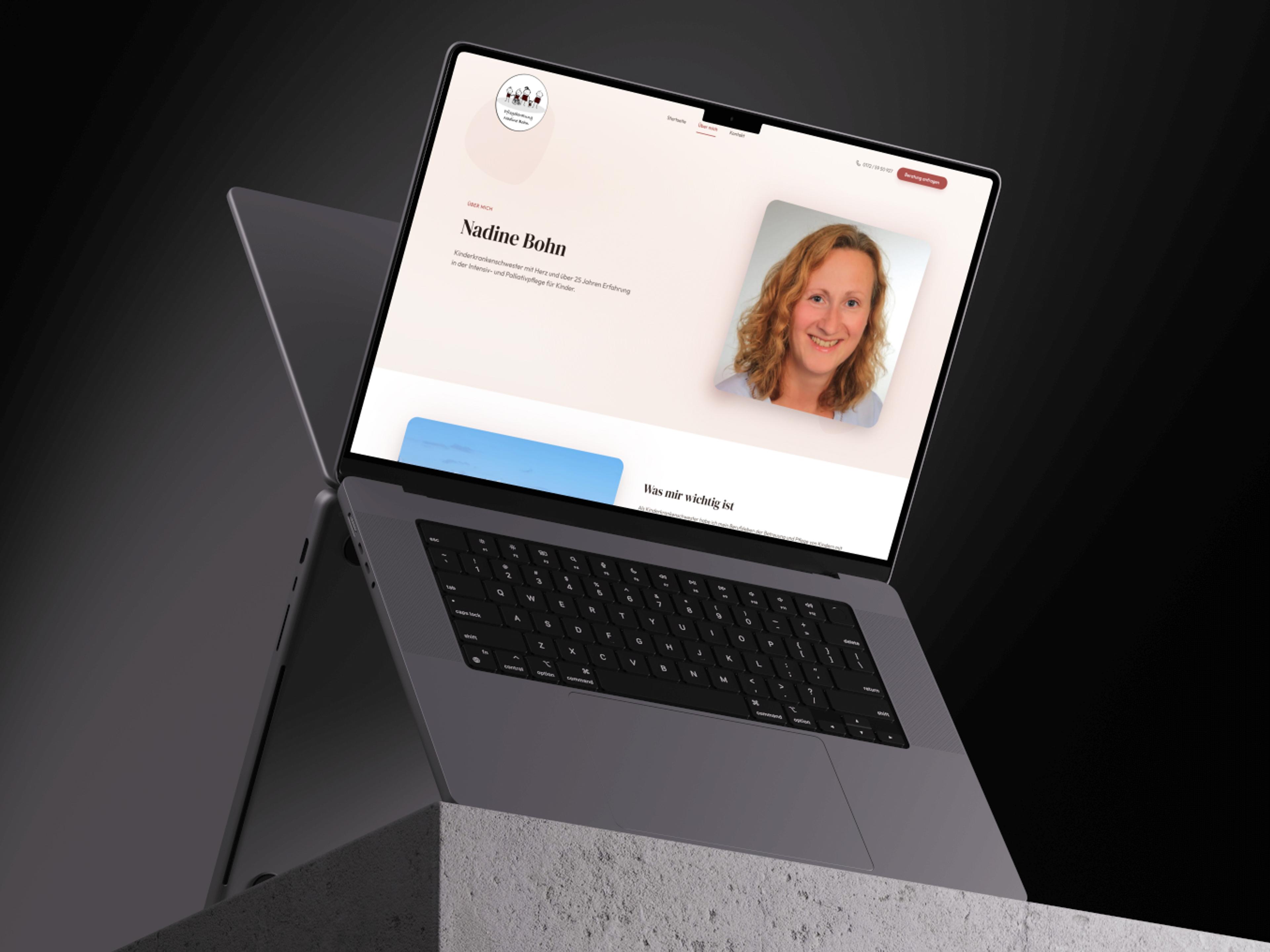 Открытый ноутбук на темном фоне, на экране отображается веб-сайт с портретной фотографией женщины