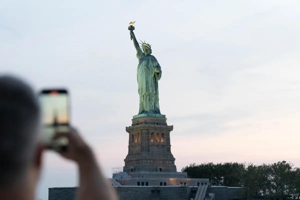 mann macht foto von der freiheitsstatue