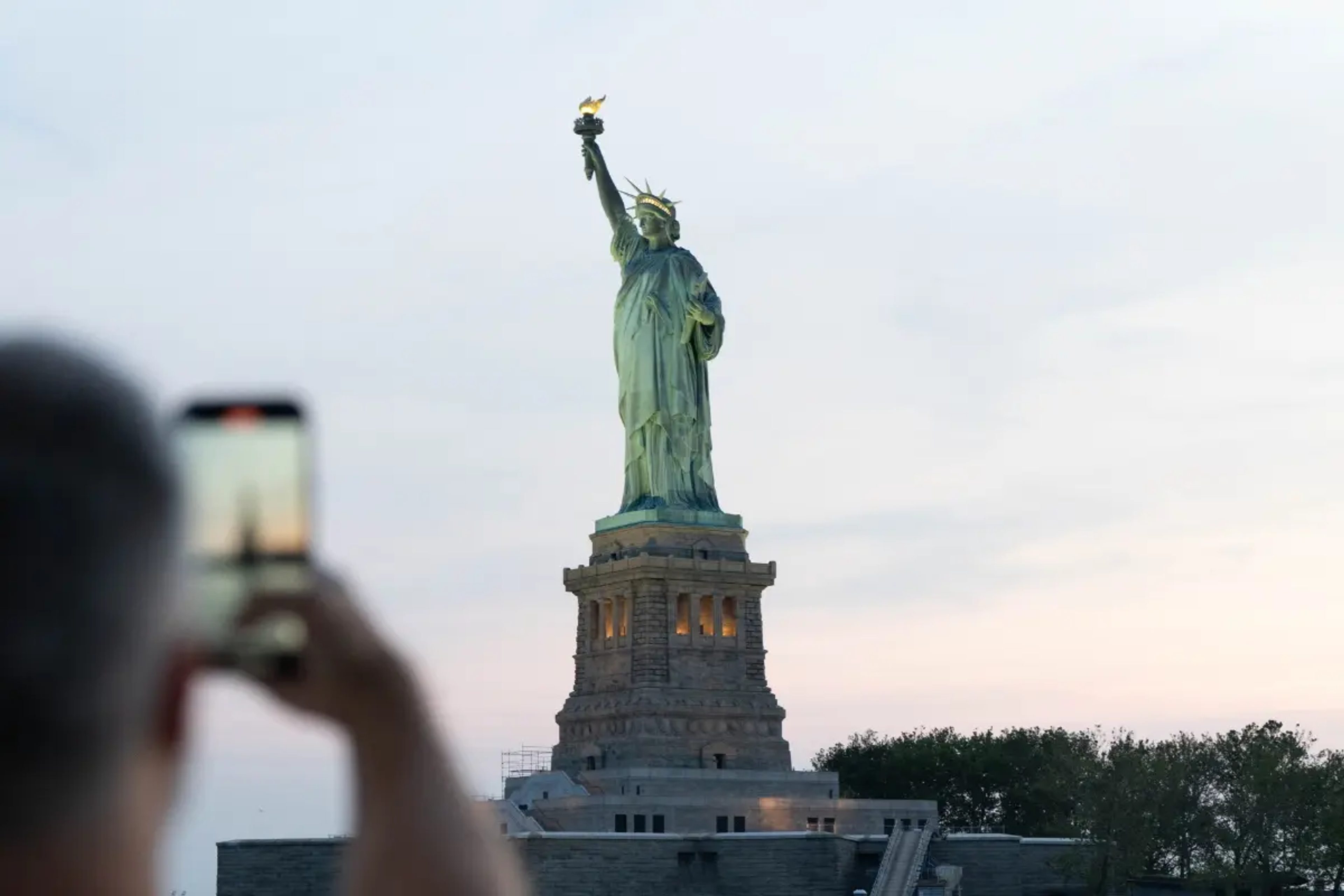 mann macht foto von der freiheitsstatue