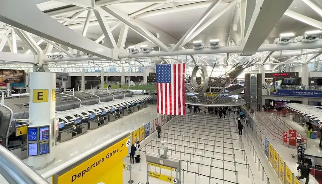 JFK airport terminal with American Flag hanging from the ceiling