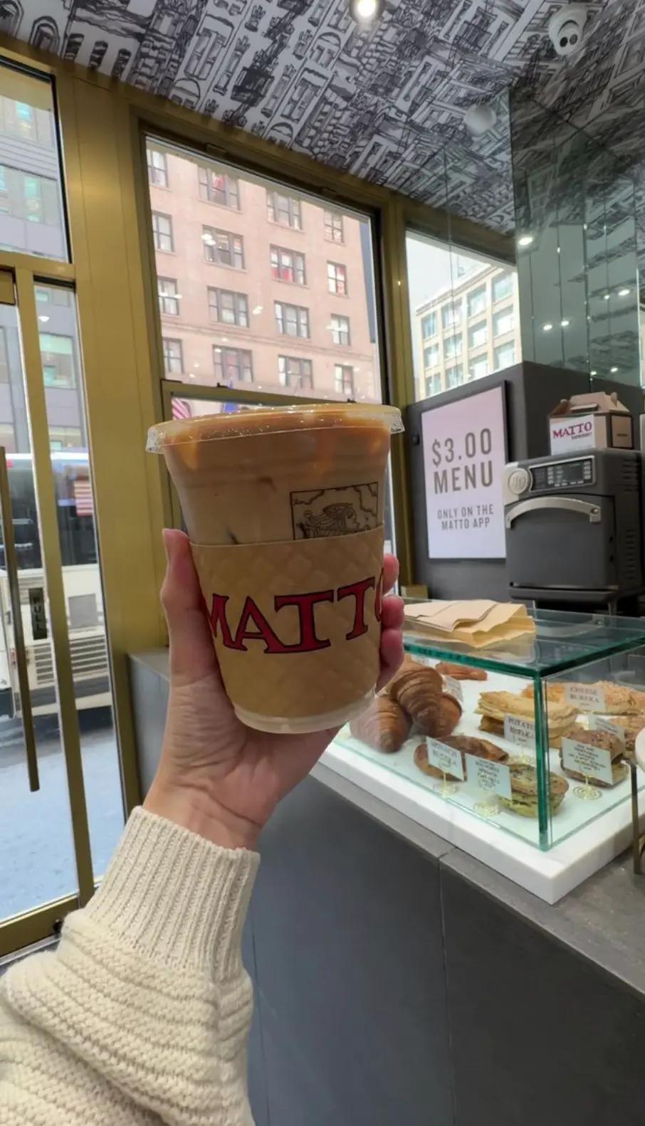 Hand holding iced latte from Matto Espresso