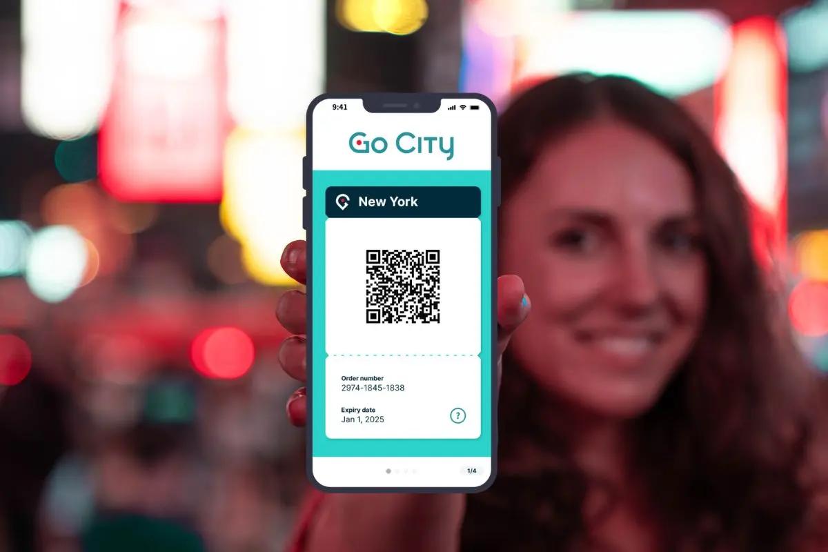 Girl holding up a phone in Times Square with Go City Pass displayed