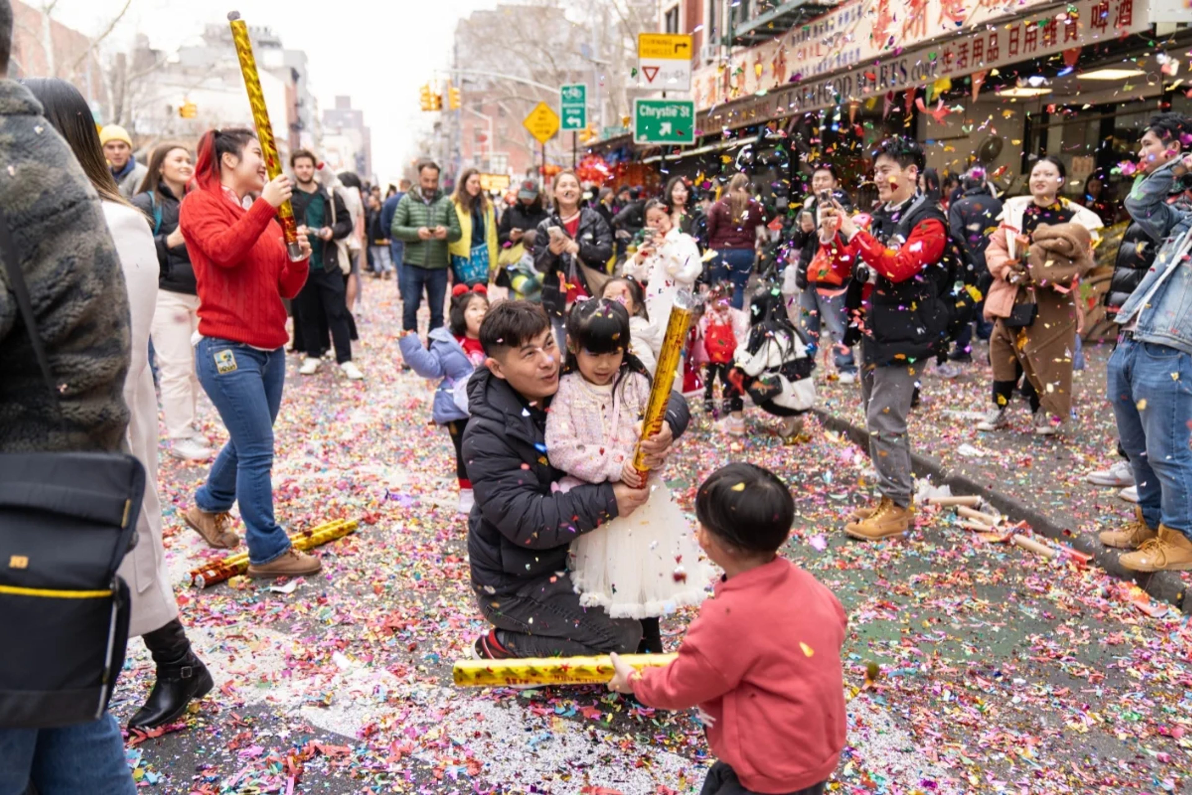 Menschen auf der Mott Street in New York mit Konfetti Popper
