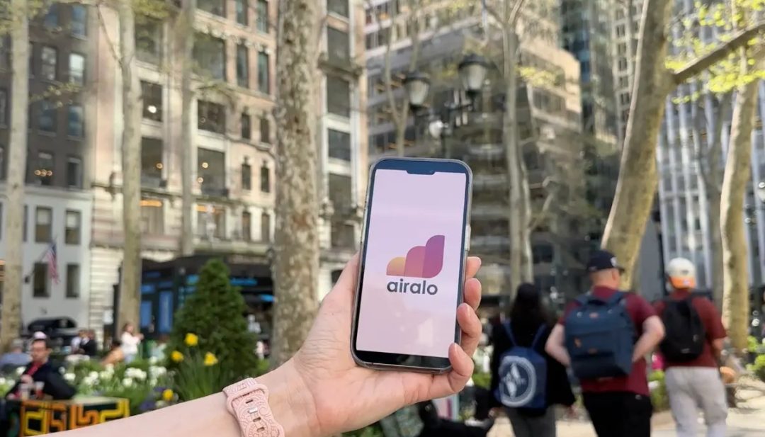 Hand holding a phone with Airalo logo