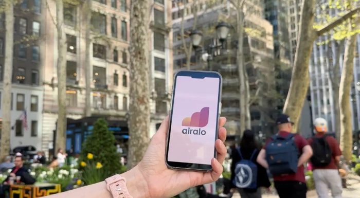 Hand holding a phone with Airalo logo