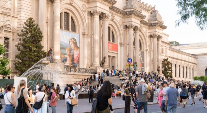People walking on Fifth Avenue in front of the Met Museum