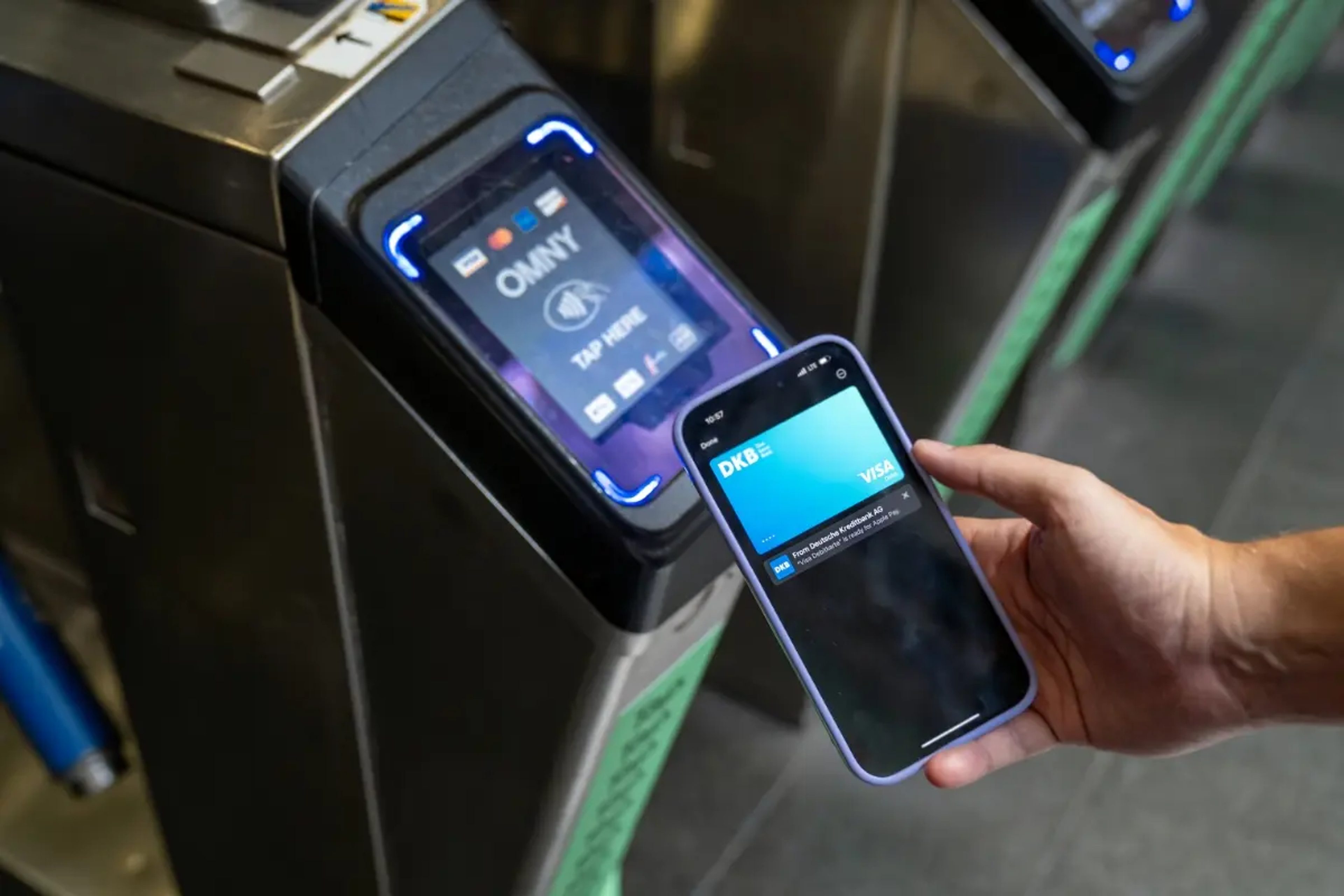 Handy und ein OMNY Lesegerät am Subwayeingang