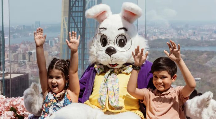 Easter Bunny and two kids sit on the Beam at Top of the Rock