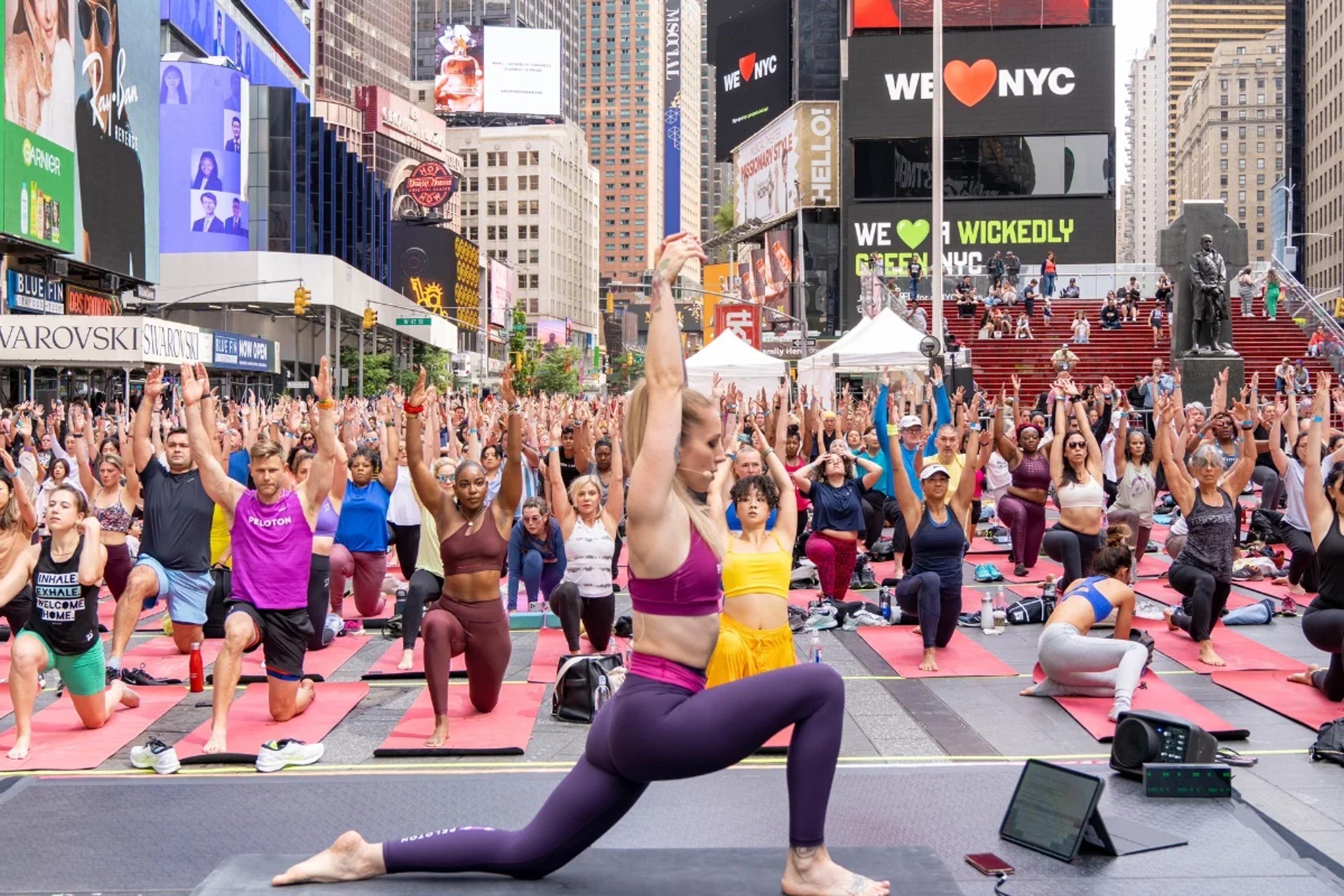 Yoga teacher in Times Square with participants in the background