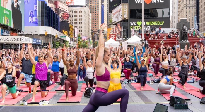 Yoga teacher in Times Square with participants in the background